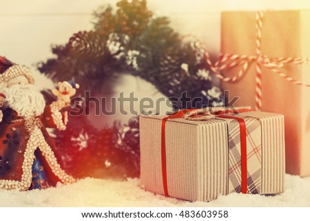 Christmas gift boxes wrapped in brown paper with red ribbon on snow background in vintage style. Shallow focus