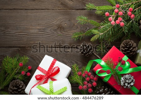 Christmas gift boxes and fir tree branch on wooden table. Top view with copy space
