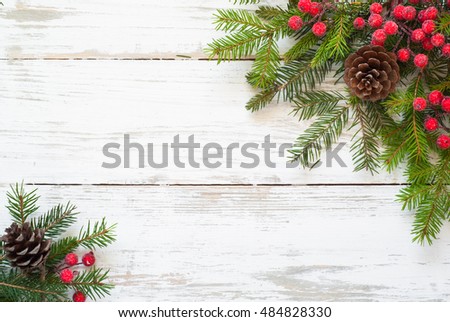 Christmas tree branch, decorations and gift box on white wooden table.