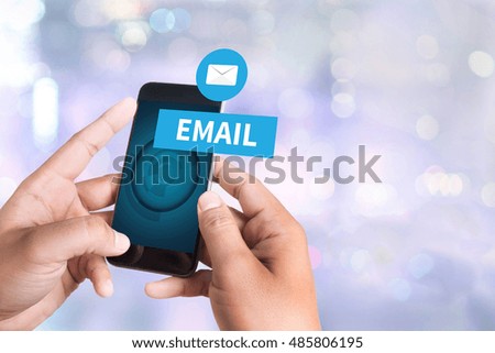 EMAIL person holding a smartphone on blurred cityscape background