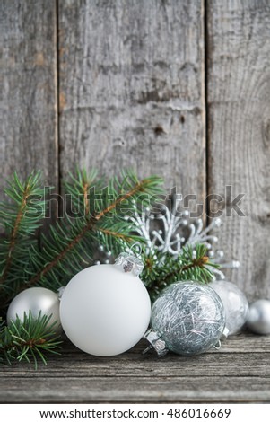 Silver and white christmas ornaments, xmas tree on rustic wood background. Merry christmas card. Winter holiday theme. Happy New Year. Space for text.