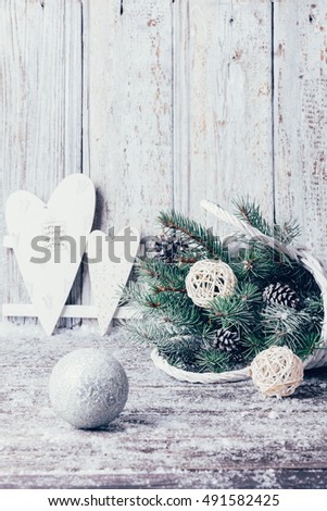 Composition with Christmas decorations in basket, fir tree on wooden background