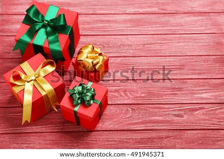 Gift boxes with ribbon on red wooden table