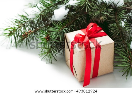 Christmas fir and gift box with red ribbon on white background