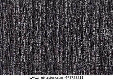 Black and white background of a knitted textile material with pattern of vertical lines. Fabric with a striped texture closeup.