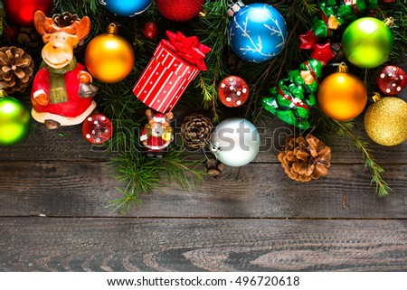 Merry Christmas Frame with real wood green pine, colorful baubles, gift boxe and other seasonal stuff over an old wooden aged background