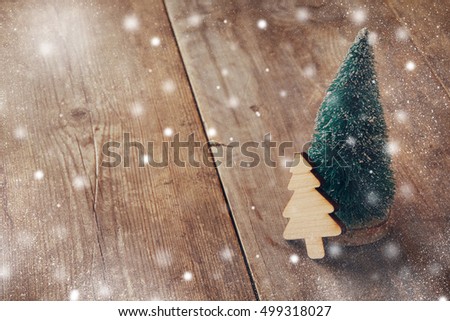 Christmas concept. Decorative tree on wooden table. Selective focus. Snow overlay