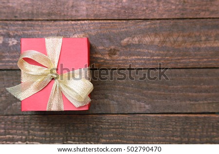 Christmas Composition with Gift box and light, red balls on wooden table.