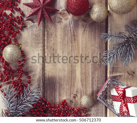 Christmas frame with Christmas balls, gift and shopping basket on a wooden background