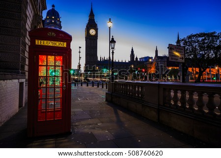 Famous English red telephone boxes with Big Ben in London at night, England, UK