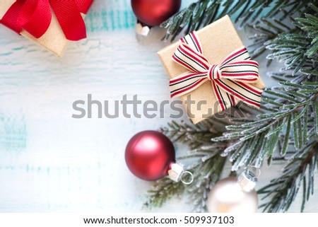 Christmas background with fir branches in snow, wrapped Christmas gifts and festive baubles with plenty of copy space for your Xmas greetings