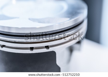 Detail of automobile engine piston. Photo closeup, shallow depth of field. Abstract industrial background.