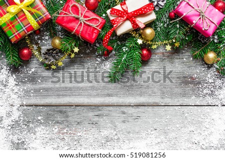 Christmas background with decorations, gift boxes and fir tree on wooden board