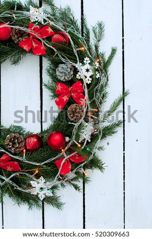 Christmas wreath of tree branches on wooden background decorated with Christmas decorations