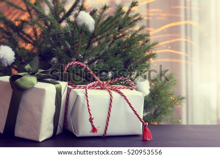 gifts with festive ribbons and bows lying on the background of trees and flying lights / atmosphere Merry Christmas