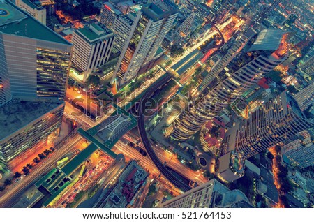 Birds eye view of a modern building at night. Traffic in the business district The Skytrain station Chong Nonsi. Vintage Style.