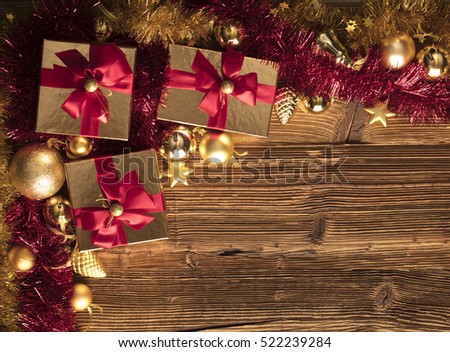 Golden presents with red ribbon. Wooden background and table. Red and gold. Place for typography and logo. Copyspace. Top view.