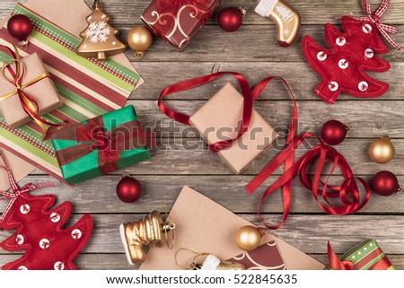 Christmas ornaments, gifts and wrapping paper on a gray wooden background.