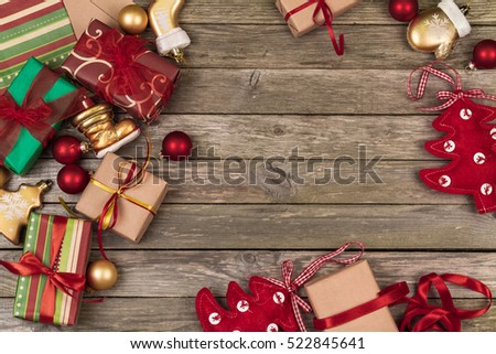 Christmas ornaments, gifts and wrapping paper on a gray wooden background.