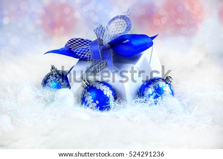 Christmas. holiday gift in a beautiful package and blue glass balls on festive background.in the photo there is an empty space for your text