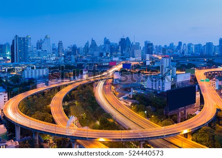 Long exposure, highway road curved with city downtown background at twilight