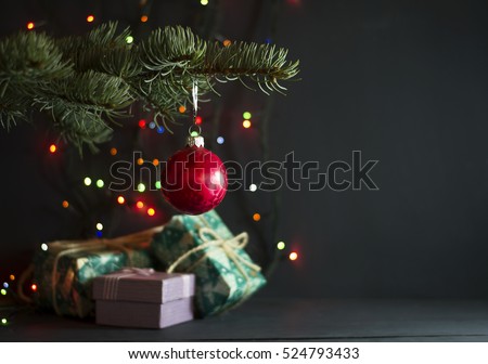 Christmas gifts under a pine tree on a blue wooden background