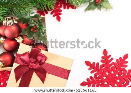 Paper gift box with a red bow and Christmas balls, on white background.
