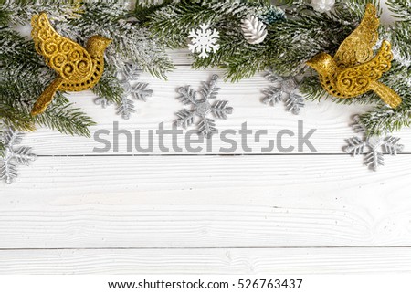 Christmas toys and spruce branches on wooden background top view