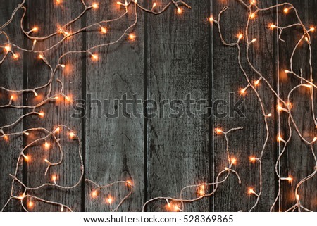 Christmas lights dark frame on grey wooden background