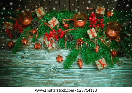 Christmas or New Year background: gifts, colored glass balls, decoration, candle on wooden background with snow