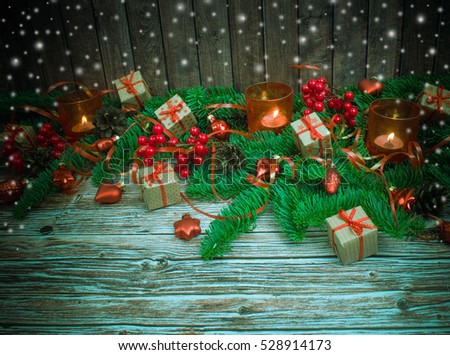Christmas or New Year background: gifts, colored glass balls, decoration, candle on wooden background with snow