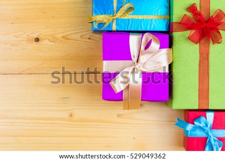 Present boxes on wooden background greeting card holidays concept. Christmas colorful gift boxes on wooden table. Top view with copy space