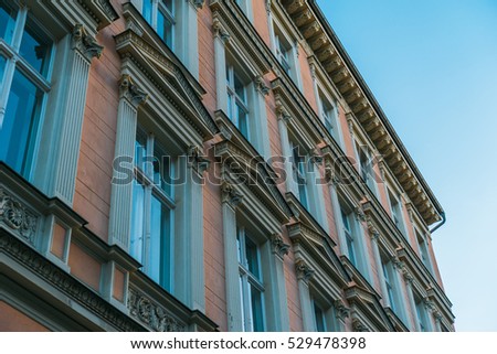 orange brick facade with blue windows and sky