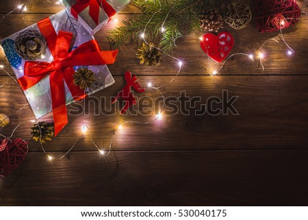 Christmas presents in gift boxes at brown wooden table. Flat lay with copy space Christmas decorations and objects Christmas fir tree branches, hearts, cones. garland Free space