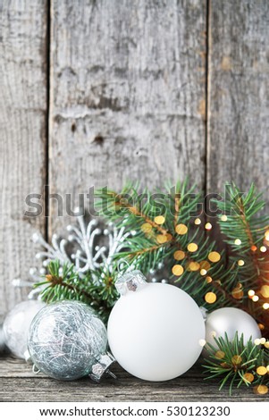 Silver and white christmas ornaments, xmas tree on rustic wood background with sparkle bokeh lights. Merry christmas card. Winter holiday theme. Happy New Year.