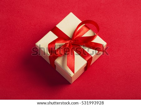 Gift kraft square box with a red ribbon on a red background