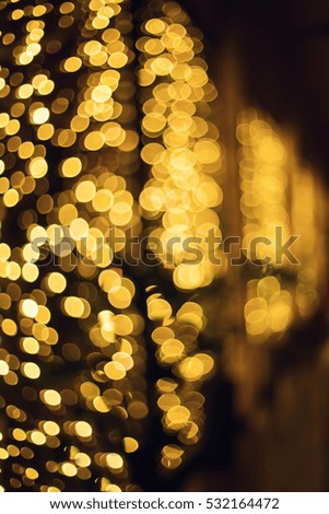 Glitter lights background. Holiday bokeh texture. Dark gold and black. Defocused