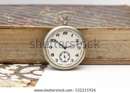 Old pocket watch near old book