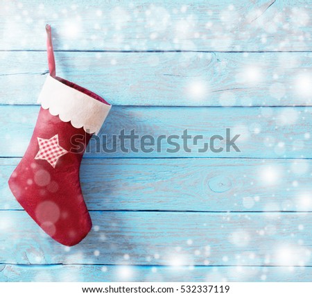 Christmas sock with gifts on  wooden wall