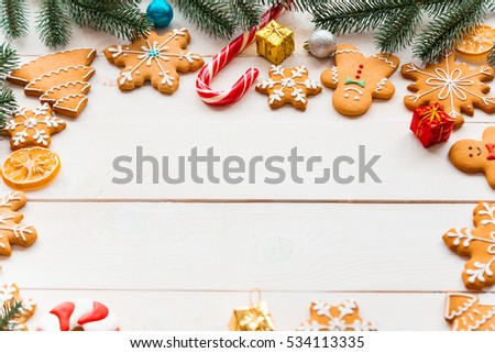 Christmas cookies with candy, gifts and fir festive with decor. Gingerbreads on white wooden background. Frame with free space for your text