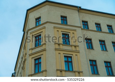 yellow corner house with blue windows