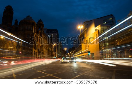 Light trails of cars and buses moving with speed at Piccadilly avenue near the main train station in the city of Manchester in England