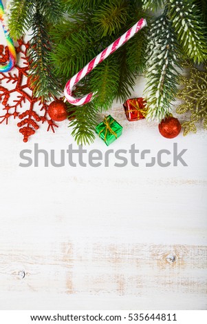 Christmas decorations, gifts and fir branches on a wooden table. Christmas border closeup.