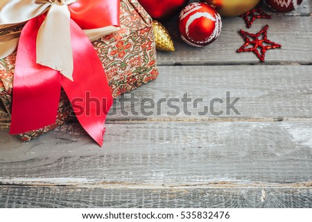Christmas background with decorations and gift box on wooden board. toned image. copyspace for text