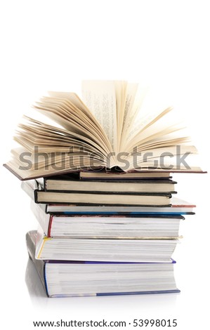 Open book on stack of various books isolated on white background.
