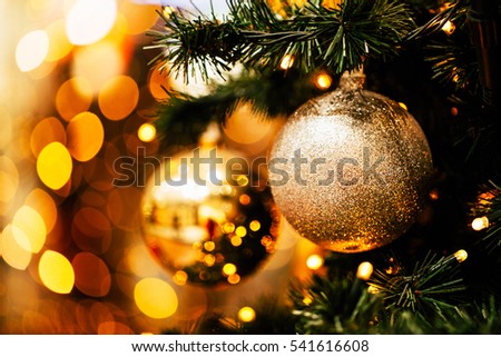 Fir branch with balls and festive lights on the Christmas background with sparkles.