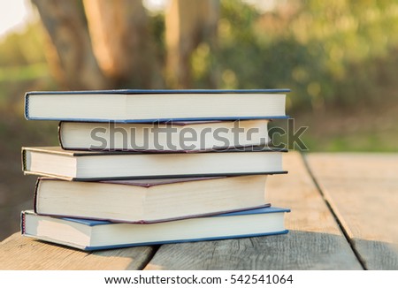 Pile of closed books outside background.