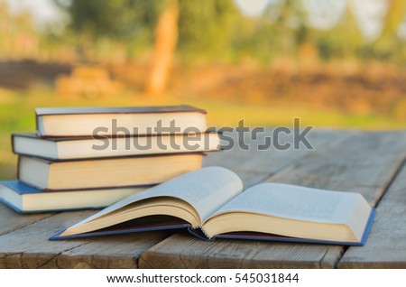 Pile of closed book and pen book on wooden background.