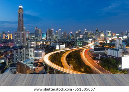 Opeing wooden floor, highway road curved with city downtown background at twilight, long exposure