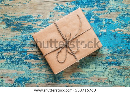 Vintage gift box brown paper wrapped with rope on wood background 